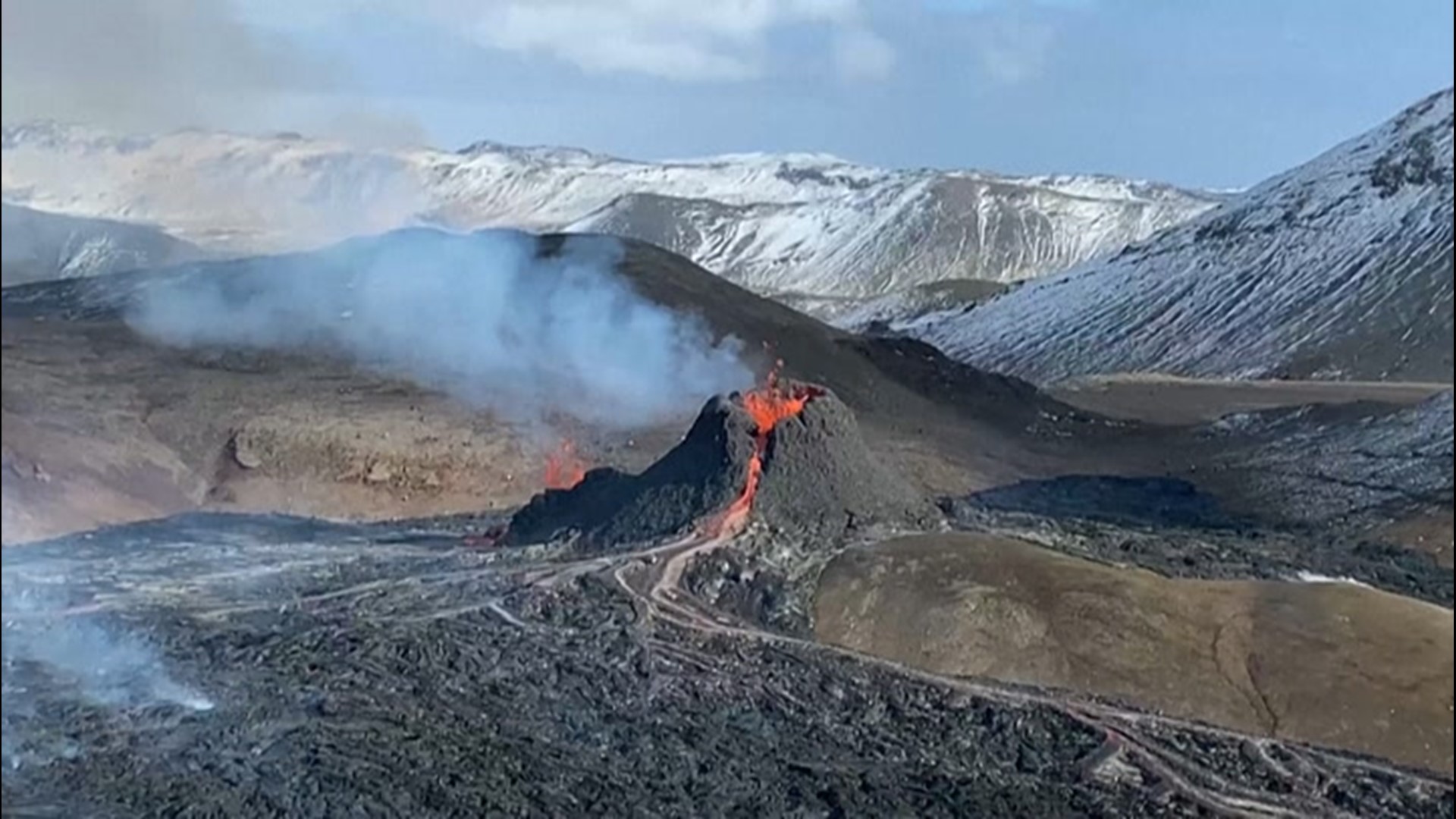 The eruption of a fissure near Mount Fagradalsfjall continued on March 23, with lava glowing red and steam rising high into the air.