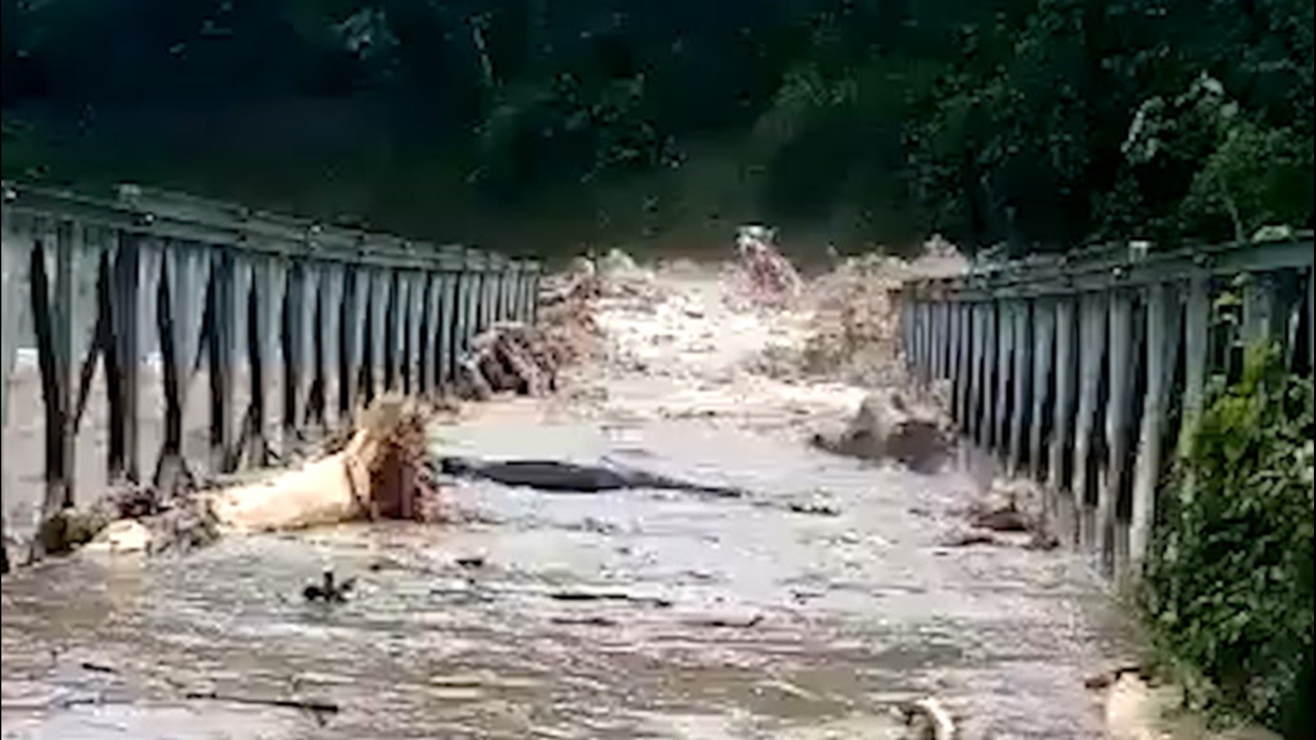 Torrential rain and flooding from Iota overwhelm this bridge in Olanchito, Honduras, on Nov. 17. The swollen Uyuca River rages through the bridge carrying debris.