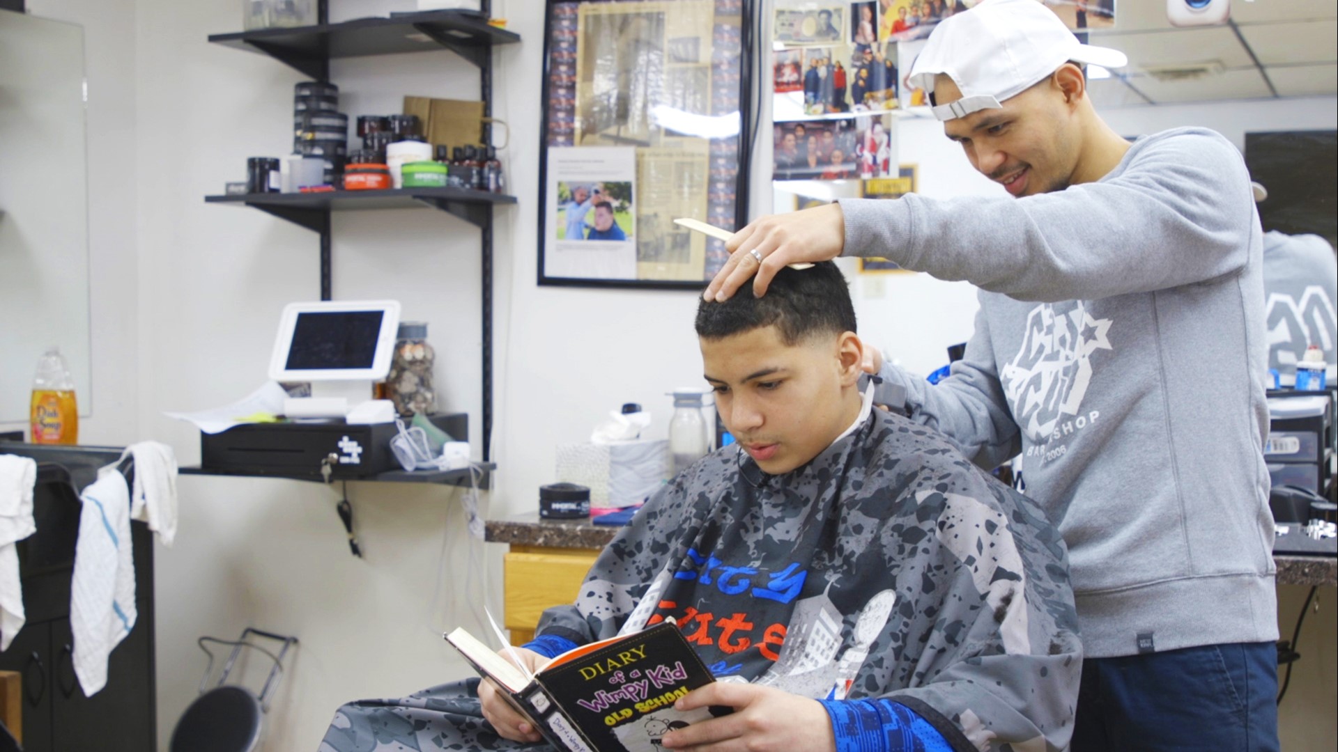 Jon Escueta works to promote literacy and confidence through his "Books By Kids" program at City Cuts barbershop in Kutztown, Pa.