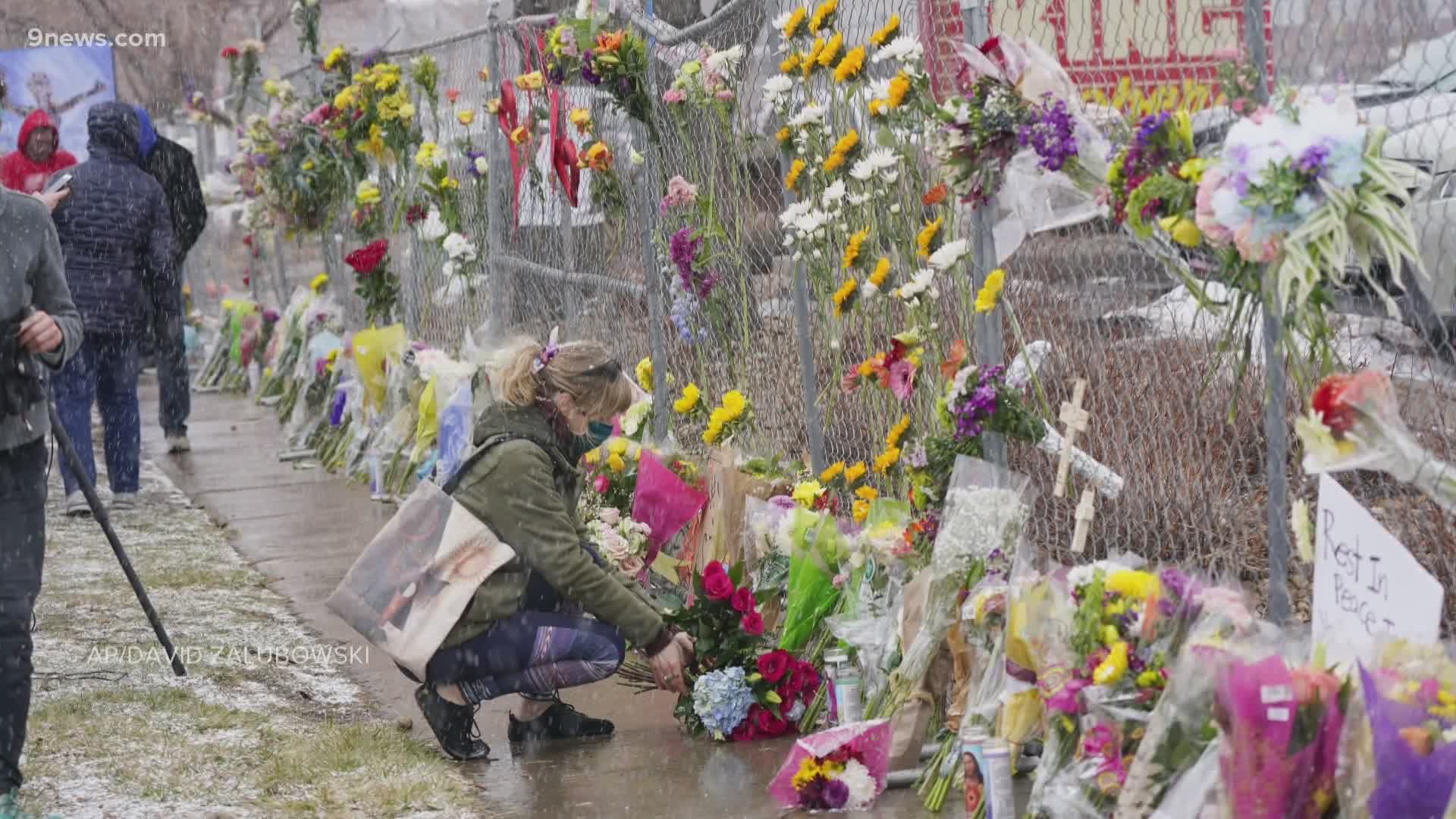 The fence around the King Soopers in Boulder has become a wall of flowers and notes to remember the victims of Monday's shooting.