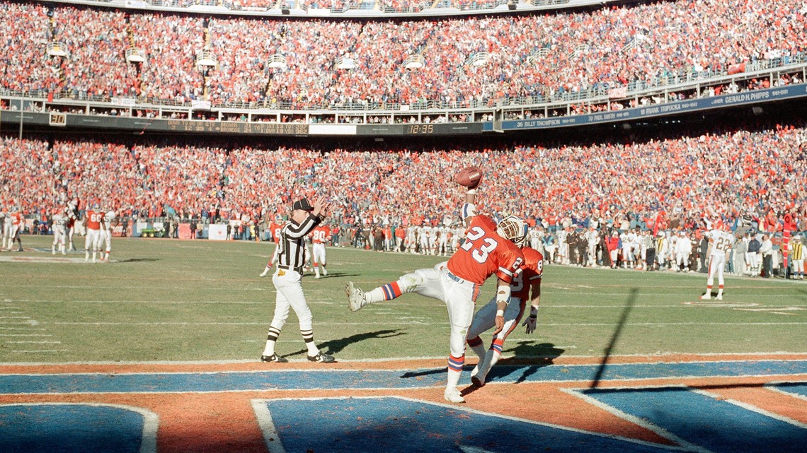 As Denver quarterback John Elway (7) watches, Broncos running back Sammy  Winder (23) carries the ball for a third quarter Denver touchdown, Jan. 14,  1990 in the AFC Championship Game in Denver.