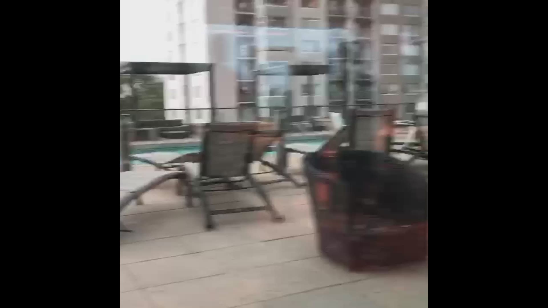 Strong winds blow furniture into a pool during storms on June 6