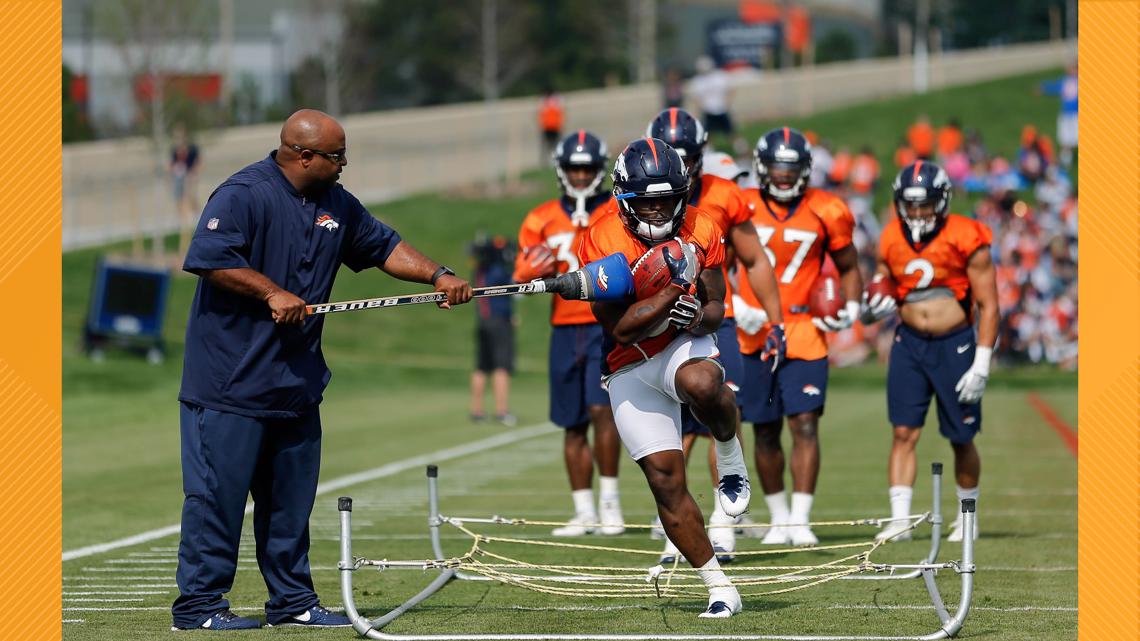 Denver Broncos running backs coach Curtis Modkins while taking