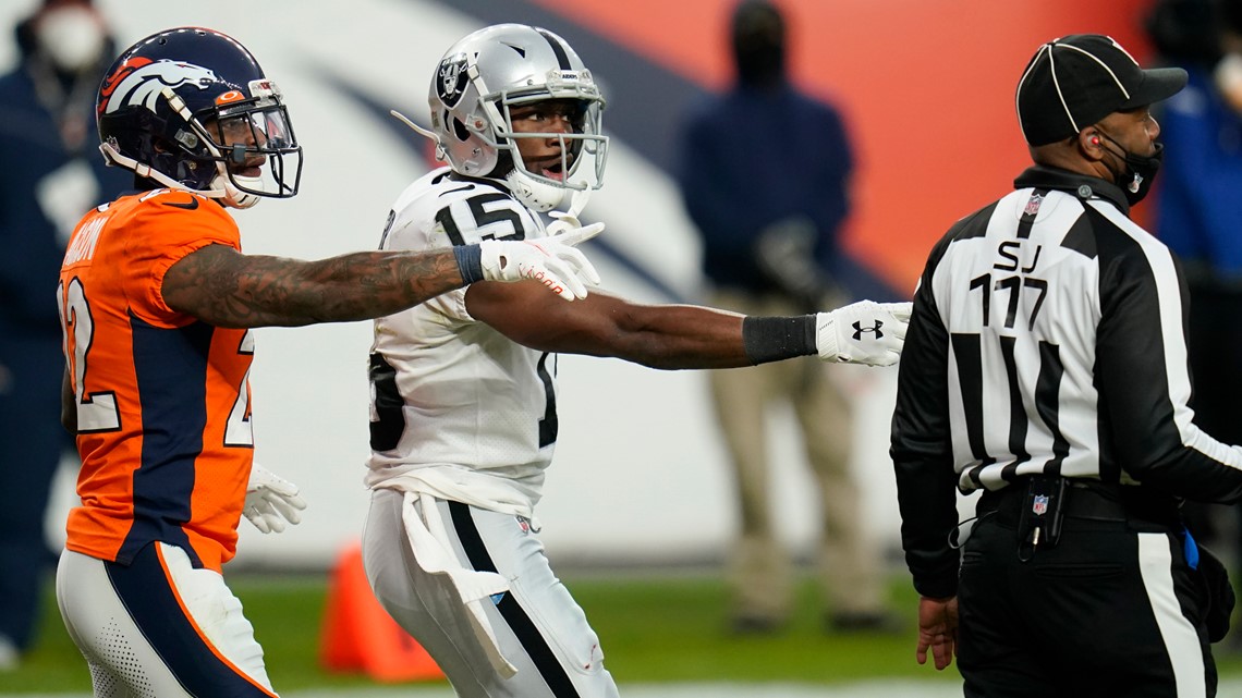 Denver Broncos guard Graham Glasgow (61) runs onto the field next to a  member of the military before an NFL football game between the Broncos and  the Las Vegas Raiders in Denver