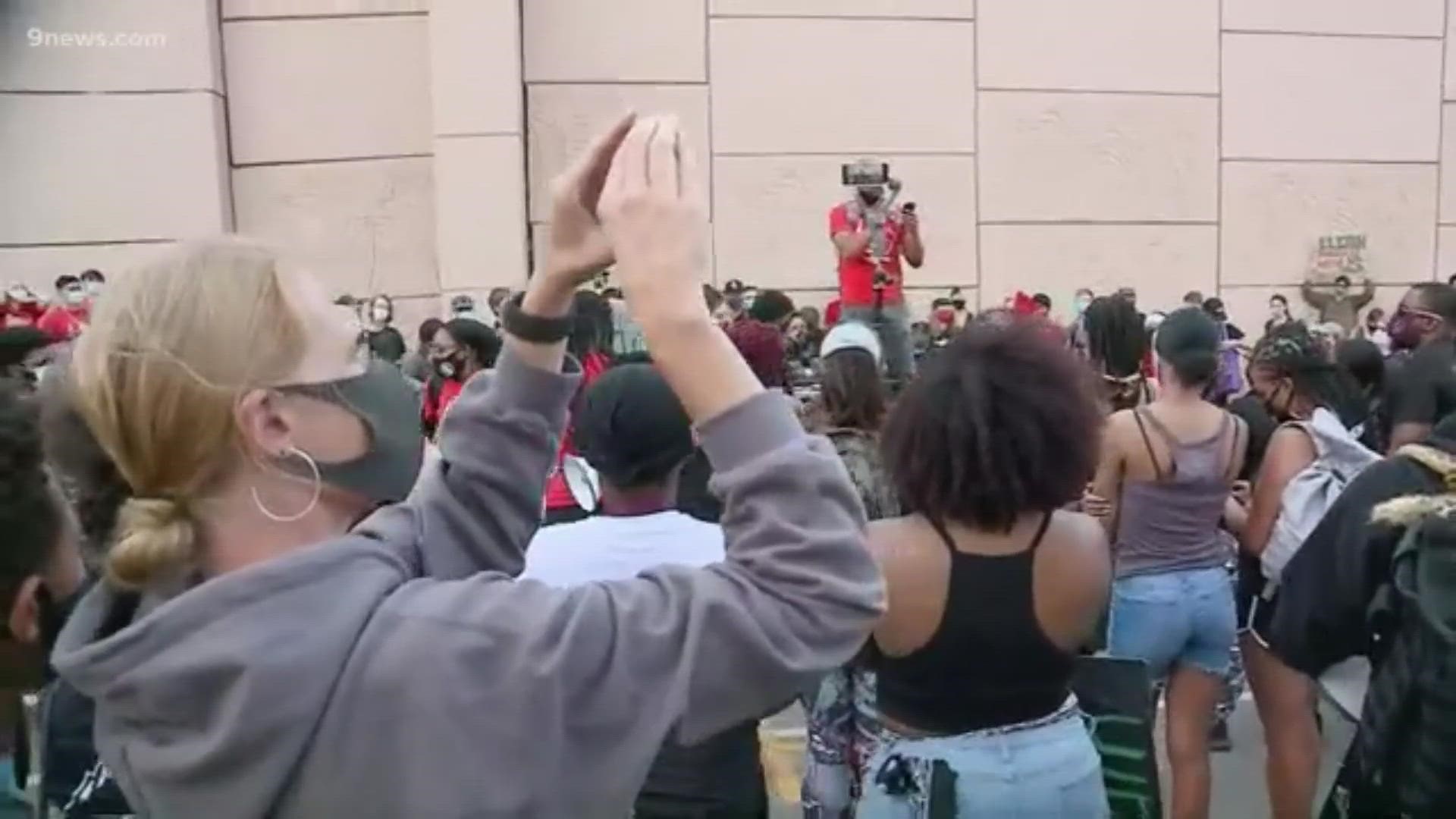 Protesters gather in Aurora Friday afternoon at the site of McClain's struggle with police. (Warning: Video contains profanity)