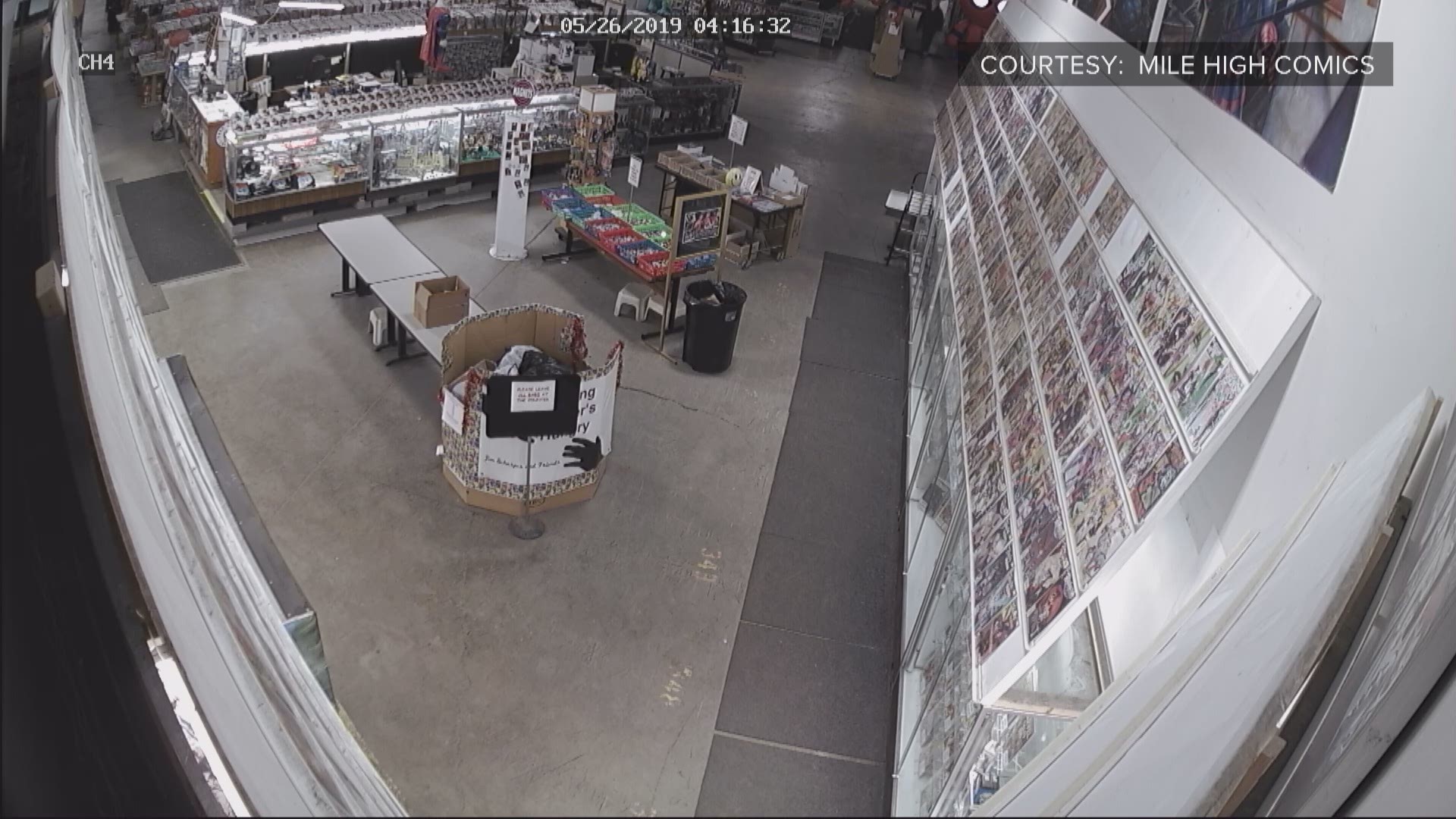 A thief is seen at Mile High Comics using some kind of metal object to break the glass, then removing books one at a time. At some point it appears he cuts himself on the arm or hand, then retrieves cleaning supplies from inside the store and begins cleaning up the blood and mess.