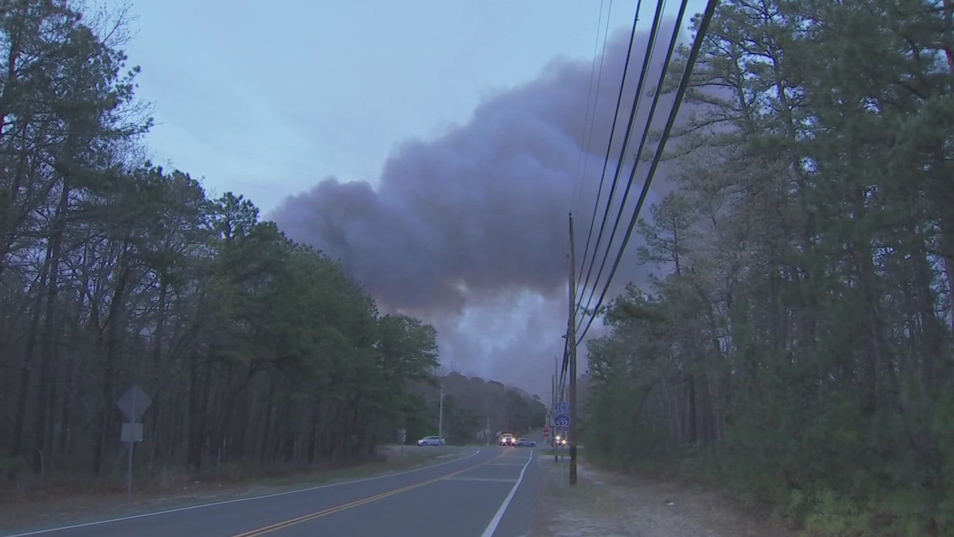 A fast-moving wildfire burning in New Jersey on Tuesday forced thousands of people to evacuate and closed a stretch of a major highway.