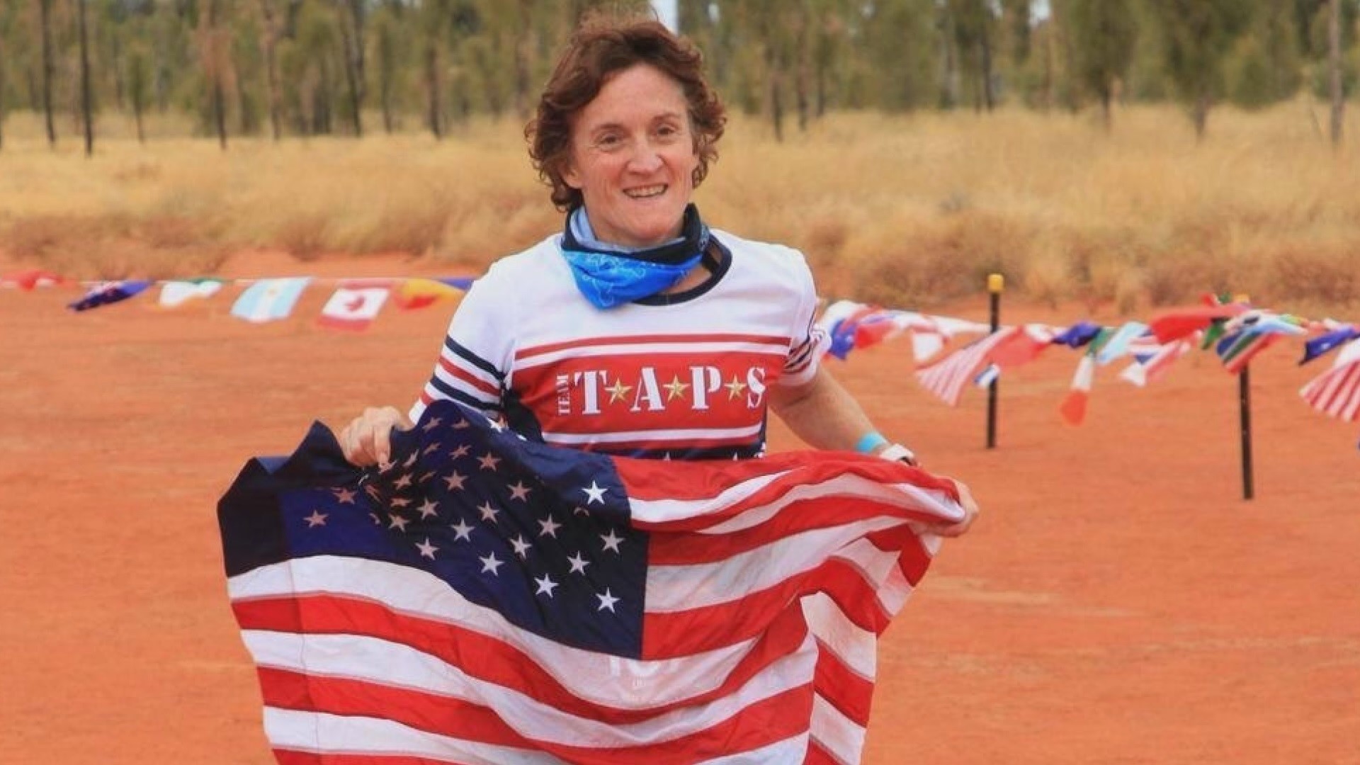 Linda Ambard of Colorado Springs has completed a marathon on every continent. She runs with an American flag to remember her husband Phil.