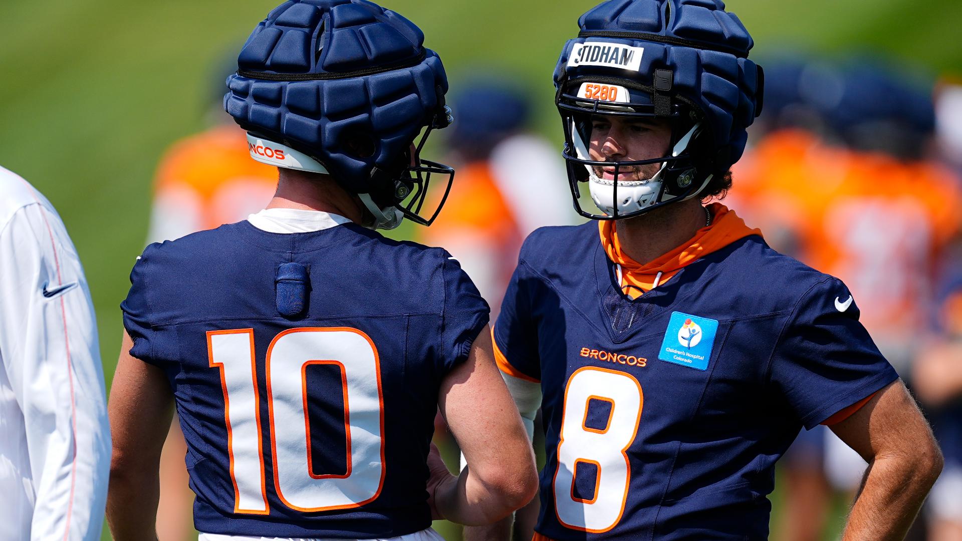 The first-round draft pick still has to carry the pads and helmets of the Denver Broncos' veteran quarterbacks.