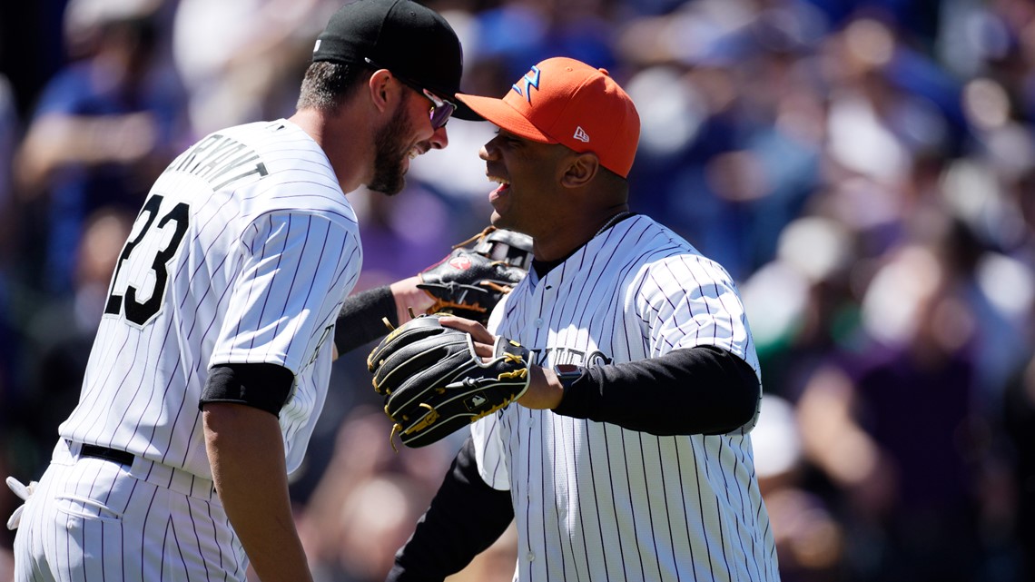 Denver Broncos quarterback Russell Wilson doffs his cap to the crowd as he  heads to the mound to throw out the first pitch during ceremonies to mark  the regular-season home opener of