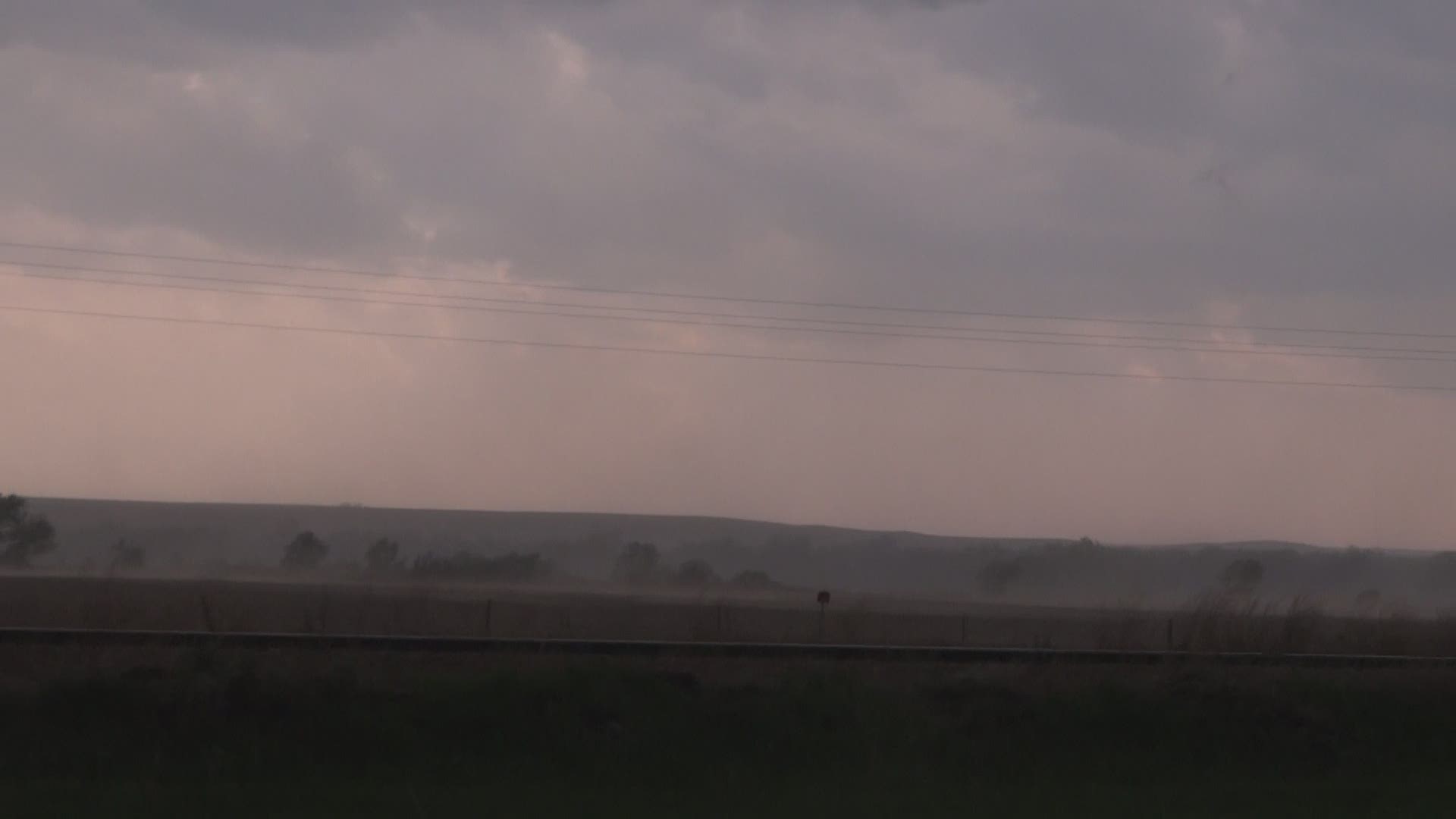 A storm chaser was in McCook, Nebraska when a twister developed around him. Video shows 50 to 60 mile per hour winds spraying dirt and sticks across his truck.
