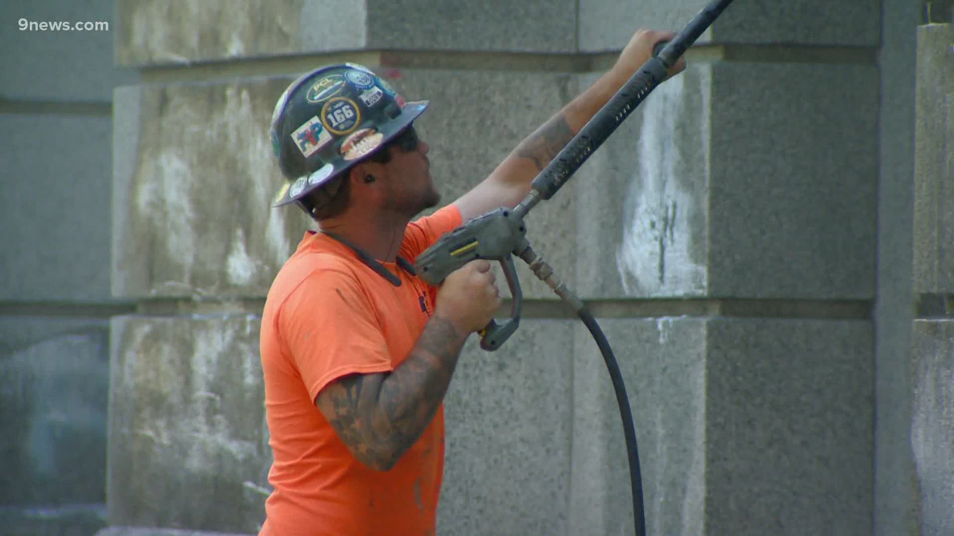 The  Capitol is fenced off as crews powerwash graffiti and repair other damages.