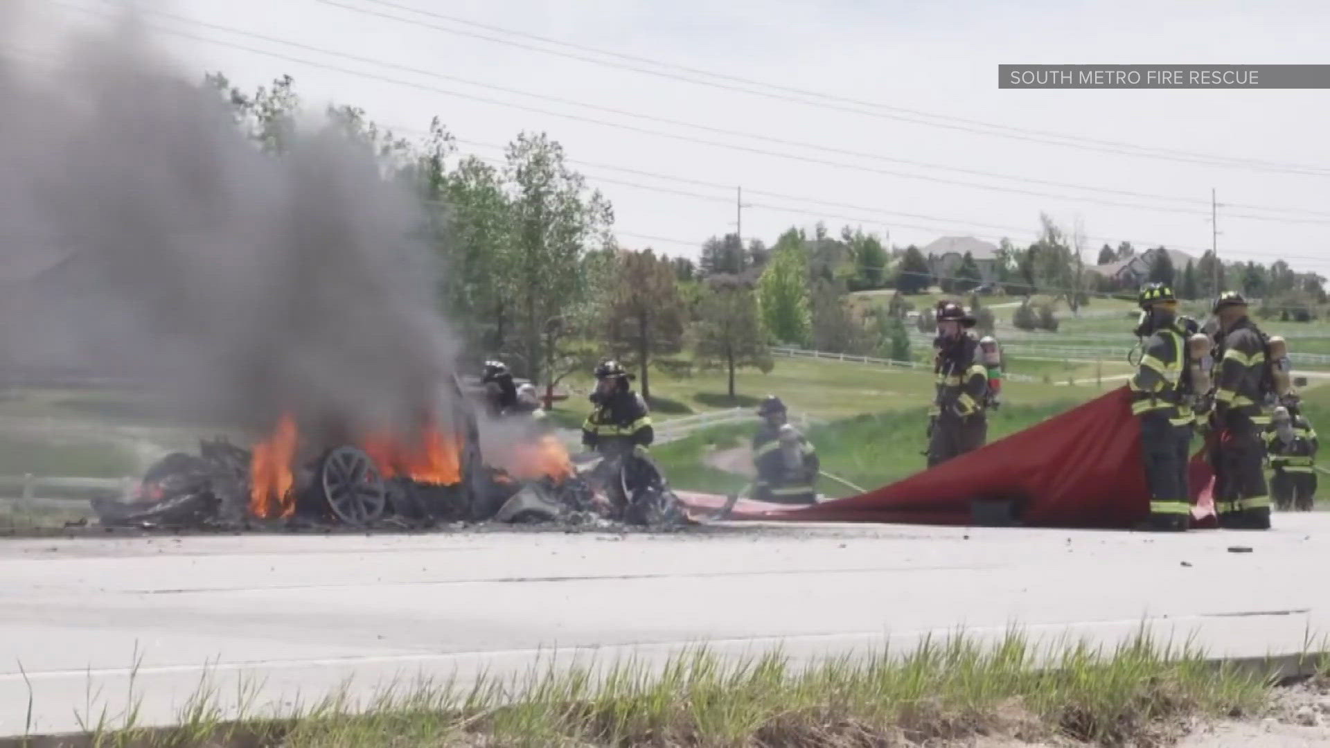 South Metro Fire Rescue said a Tesla caught fire and flames spread to nearby grass.