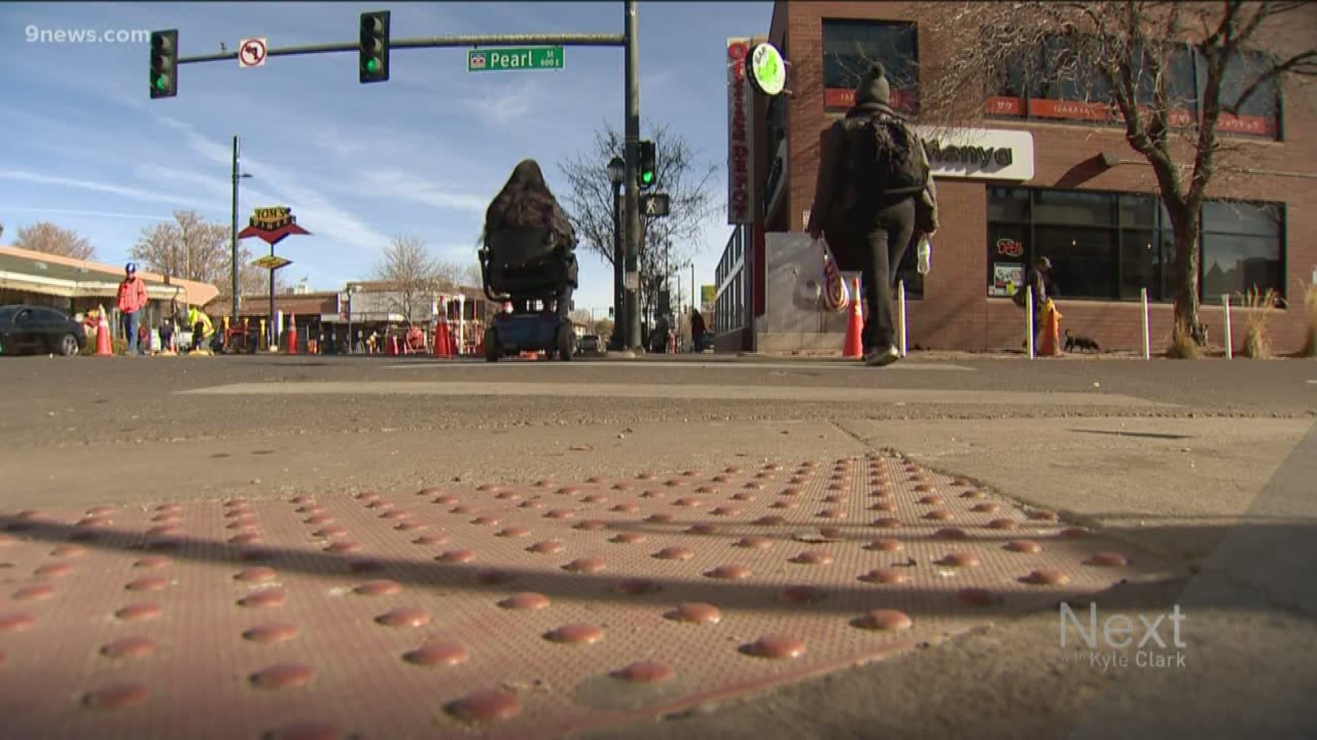 Fifteen intersections along East Colfax Avenue are getting pedestrian makeovers: posts, signs and paint to shorten the distance pedestrians need to cross.