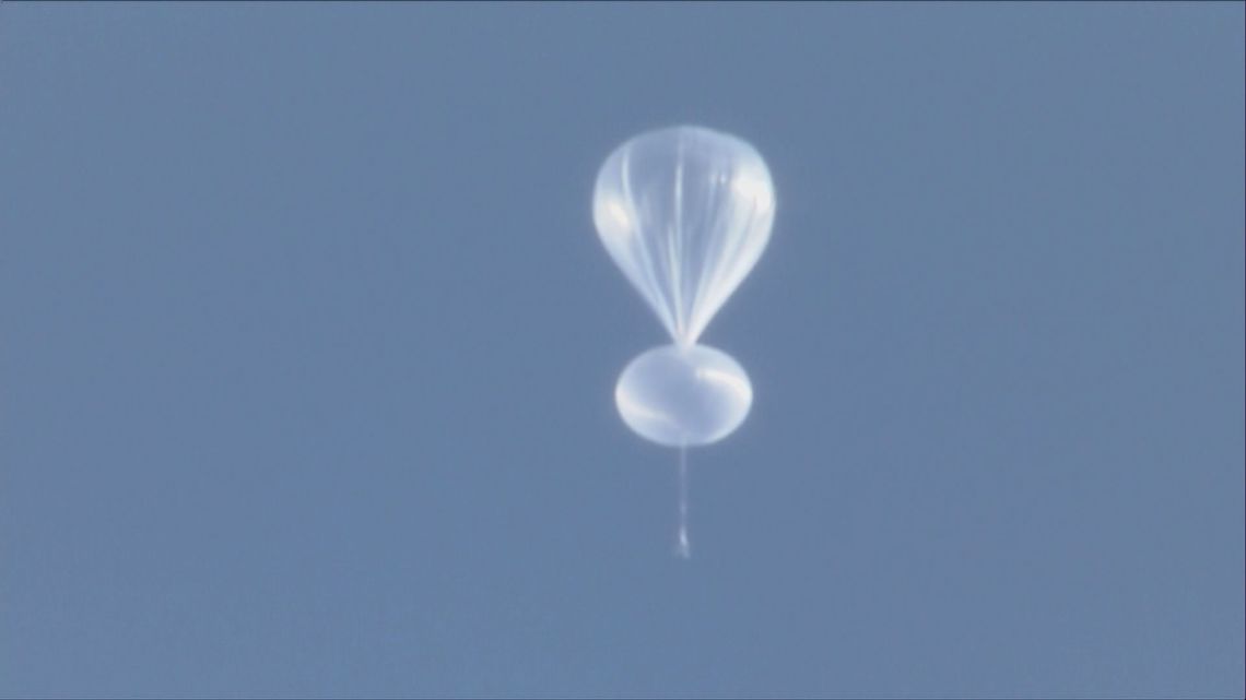 What is the white balloon flying north of Denver?