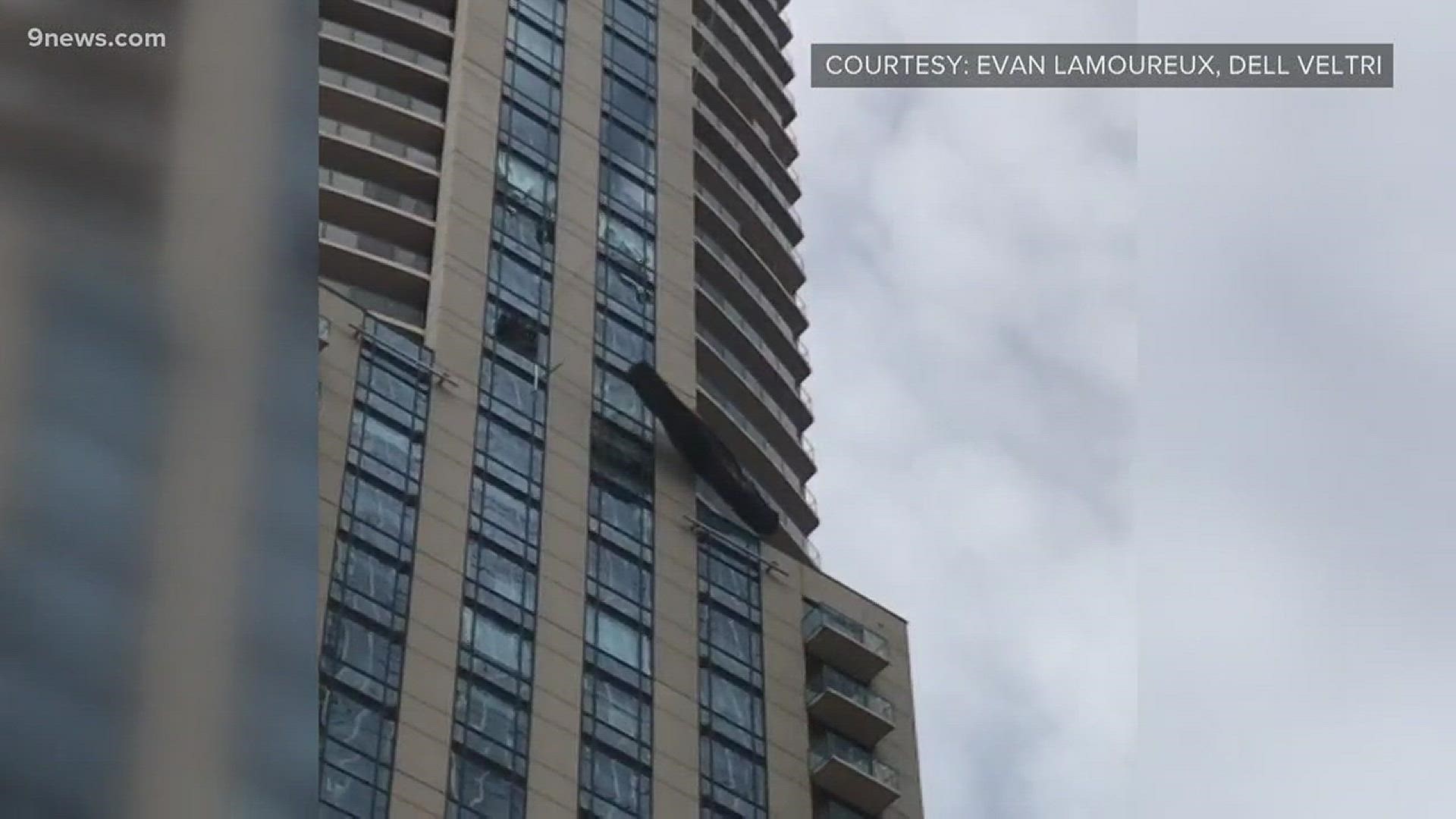 Video taken by witnesses on the street below the Four Seasons Hotel in downtown Denver shows a platform blowing in the wind after crashing into the building.